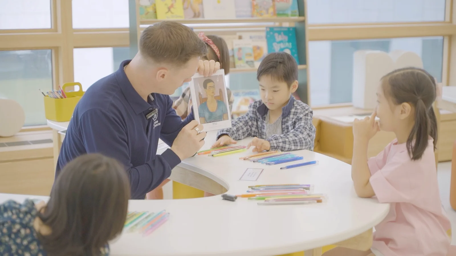 A Crew member leading a play-based English activity with children ages 4–9